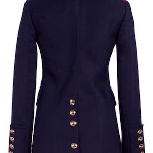 K&ouml;nnte beinhalten: Eine marineblaue Jacke mit rotem Besatz und goldenen Kn&ouml;pfen. Die Jacke hat einen Stehkragen und lange &Auml;rmel.