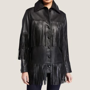 May include: A black leather jacket with fringe detailing. The jacket has a button-up front and long sleeves.