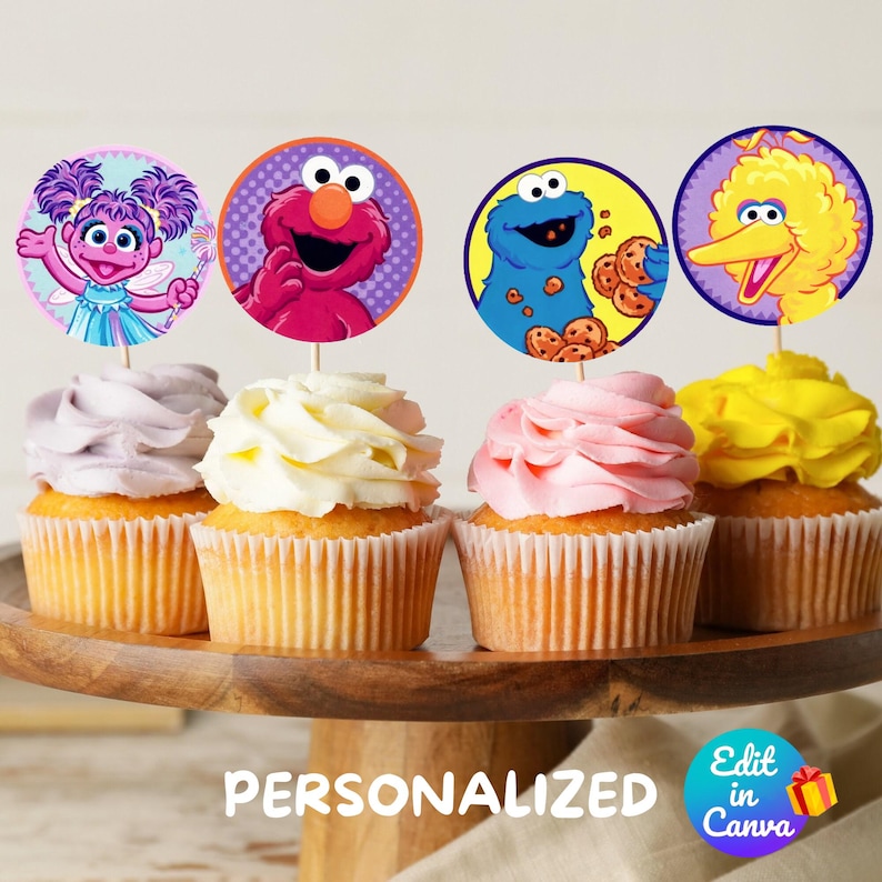 May include: Four cupcakes with colorful frosting topped with round edible images of Sesame Street characters: Elmo, Cookie Monster, Big Bird, and Abby Cadabby. The cupcakes are on a wooden cake stand. The text "PERSONALIZED" is on the stand. The text "Edit in Canva" is on a small square with a gift box icon.