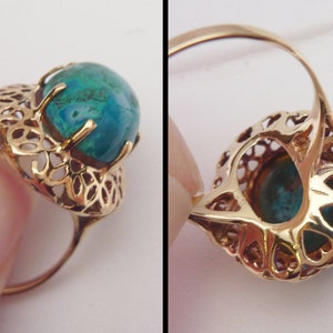 May include: Gold-toned ring featuring a round, teal-colored gemstone. The ring has an intricate filigree design around the stone and on the band's setting. The ring's design is vintage-inspired.