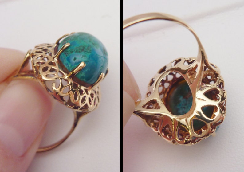 May include: Gold-toned ring featuring a round, teal-colored gemstone. The ring has an intricate filigree design around the stone and on the band's setting. The ring's design is vintage-inspired.