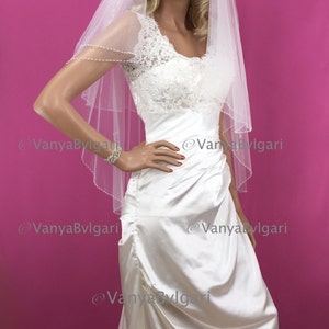 Bridal veil in two tier with beaded edge and beaded flower designs in fingertip length in light Ivory color with gathered top on a comb