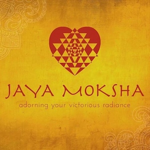 Puede incluir: Un logotipo rojo en forma de coraz&oacute;n con un patr&oacute;n geom&eacute;trico en su interior. El texto "JAYA MOKSHA" est&aacute; debajo del coraz&oacute;n, y el texto "adorning your victorious radiance" est&aacute; debajo de este.