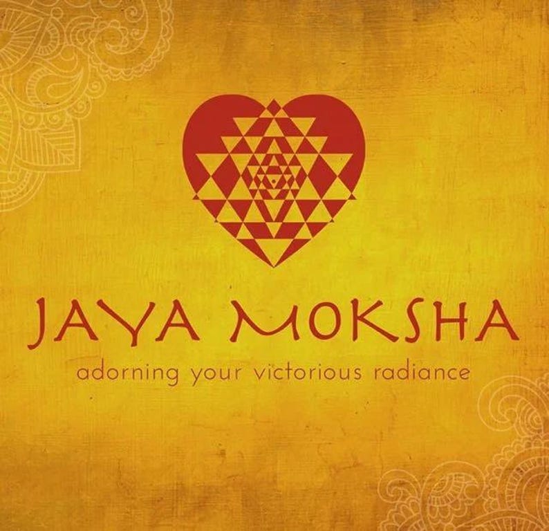 Puede incluir: Un logotipo rojo en forma de coraz&oacute;n con un patr&oacute;n geom&eacute;trico en su interior. El texto "JAYA MOKSHA" est&aacute; debajo del coraz&oacute;n, y el texto "adorning your victorious radiance" est&aacute; debajo de este.