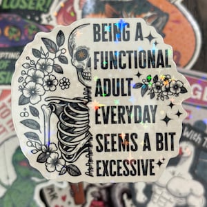 May include: A holographic sticker with a half-skeleton and floral design. The text reads "BEING A FUNCTIONAL ADULT EVERYDAY SEEMS A BIT EXCESSIVE". The sticker has a white background and is surrounded by other stickers.