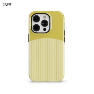 Puede incluir: Una funda para smartphone con diseño bicolor, que presenta una sección superior en amarillo mostaza sólido y una sección inferior en amarillo pálido con rayas verticales. La funda incluye un área negra para la cámara con tres lentes y flash.