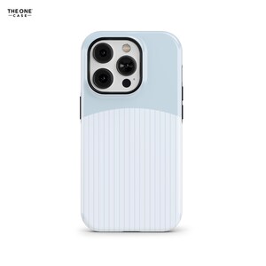 Puede incluir: Una funda para smartphone con un diseño de dos tonos, con una sección superior azul claro sólida y una sección inferior blanca con rayas verticales. El módulo de la cámara es negro con tres lentes circulares y un flash. El texto THE ONE CASE es visible.