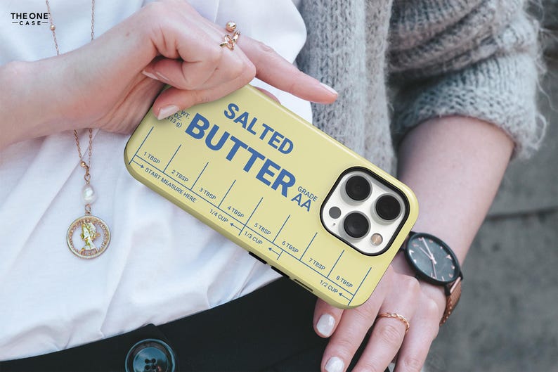 Pu&ograve; includere: Custodia per telefono gialla con la scritta blu "SALTED BUTTER". Presenta una guida di misurazione con misure in cucchiai e tazze. La custodia &egrave; progettata per uno smartphone.