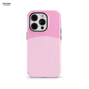 Puede incluir: Una funda para smartphone de color rosa claro con una sección superior lisa y una sección inferior con rayas verticales. El área del módulo de la cámara está delineada en negro y el texto THE ONE CASE aparece en la esquina superior izquierda.
