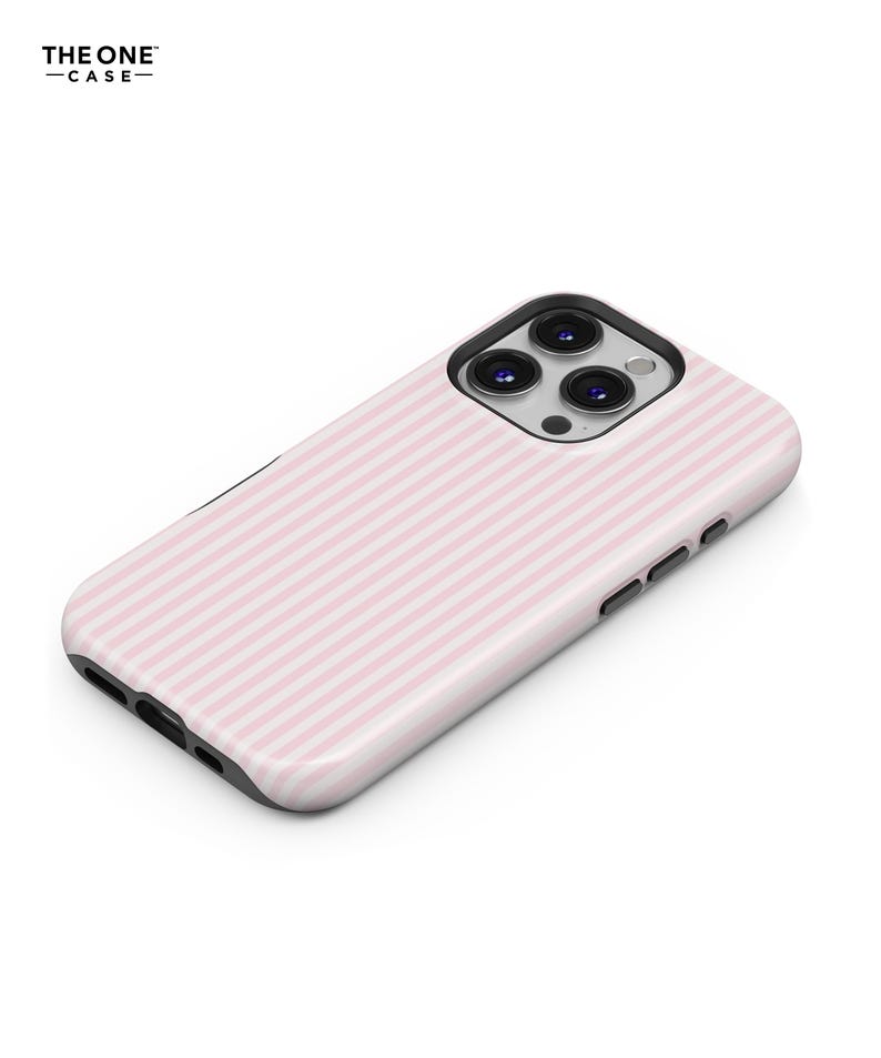 Pu&ograve; includere: Una custodia per telefono a righe rosa e bianche. La custodia ha una finitura lucida e un bordo nero. Le lenti della fotocamera sono visibili sulla parte superiore della custodia. Il testo "THE ONE -CASE-" &egrave; in alto a sinistra.