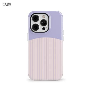 Puede incluir: Una funda protectora para teléfono con un diseño de dos tonos, que presenta una sección superior de color violeta claro sólido y una sección inferior de color rosa pálido decorada con finas rayas verticales violetas.