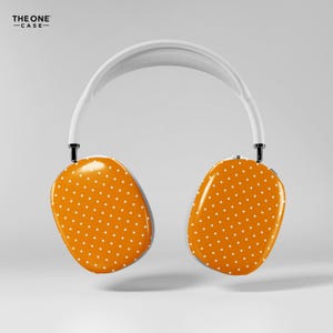 May include: White and orange polka dot headphones. The earcups are orange with a white polka dot pattern. The headband is white, and the earcups are connected to the headband with black joints. The text "THE ONE -CASE-" is in the top left corner.