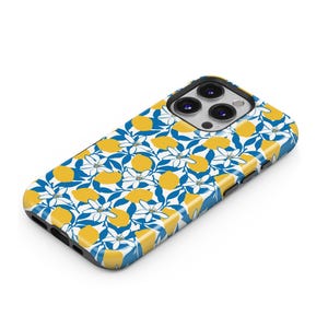 Op de afbeelding: Een telefoonhoesje met een levendig citroenpatroon. Het ontwerp toont gele citroenen, witte bloemen en blauwe bladeren op een glanzend oppervlak. De hoes heeft een zwarte camerabehuizing en de tekst "THE ONE -CASE-" linksboven.