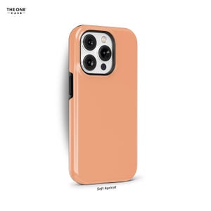 May include: A soft apricot phone case for an iPhone with a black border and a camera cutout.