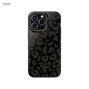Puede incluir: Funda de teléfono negra con diseño de estampado de leopardo. La funda tiene un acabado brillante y un módulo de cámara con múltiples lentes. La marca "THEONE -CASE-" está impresa en la esquina superior izquierda.