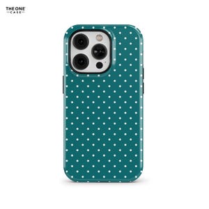 Puede incluir: Una funda para teléfono azul turquesa con un patrón de lunares blancos. La funda está diseñada para un teléfono con un sistema de cámara triple.