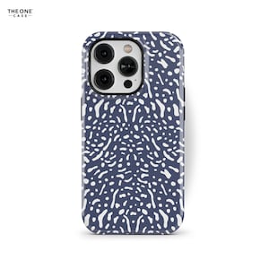 Puede incluir: Una funda de teléfono azul con un patrón abstracto blanco. La funda tiene un recorte para la lente de la cámara.