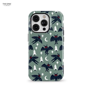 Puede incluir: Una funda de teléfono con un patrón repetido de criaturas negras parecidas a polillas con ojos rojos, estrellas blancas, lunas crecientes y pinos blancos sobre un fondo verde. La funda tiene un recorte para la cámara.
