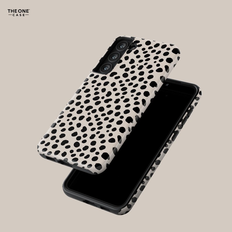 May include: A smartphone case with a cream-colored background and a black dalmatian spot pattern. The case is shown with a black smartphone, and the brand name "THE ONE CASE" is visible in the upper left corner.