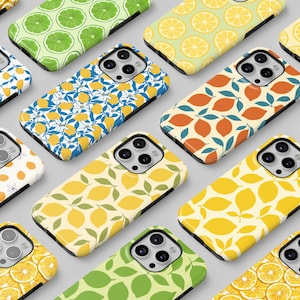 Op de afbeelding: Een verzameling telefoonhoesjes met verschillende fruitpatronen. Ontwerpen omvatten citroenschijfjes, hele citroenen en citroenbladeren in geel, groen en oranje. De hoesjes zijn gerangschikt op een lichtgrijze ondergrond.