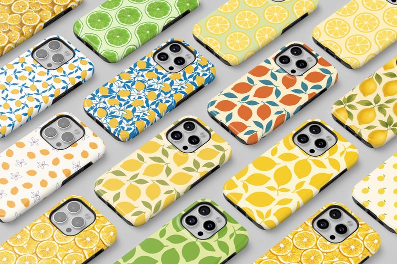 Op de afbeelding: Een verzameling telefoonhoesjes met verschillende fruitpatronen. Ontwerpen omvatten citroenschijfjes, hele citroenen en citroenbladeren in geel, groen en oranje. De hoesjes zijn gerangschikt op een lichtgrijze ondergrond.