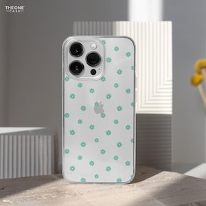 May include: A clear phone case with a pattern of small green flowers. The case is designed for a phone with a triple camera lens.