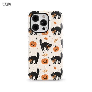 May include: A phone case with a Halloween theme. The case features a repeating pattern of black cats with orange bows, jack-o'-lanterns, and autumn leaves on a cream background. The text "THE ONE CASE" is in the upper left corner.