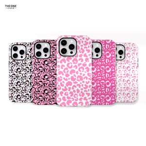Puede incluir: Cuatro fundas para iPhone diferentes con un diseño de estampado de leopardo rosa y blanco. Las fundas son todas del mismo tamaño y forma, pero cada una tiene un esquema de color diferente. La primera funda es negra y blanca, la segunda es rosa y negra, la tercera es rosa y blanca y la cuarta es blanca con un estampado de leopardo rosa.