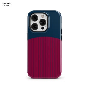 Puede incluir: Una funda para smartphone con una sección superior azul oscuro y una sección inferior rojo intenso con finas rayas verticales azul oscuro. El módulo de cámara es blanco con tres lentes y un flash. El texto THE ONE CASE es visible.