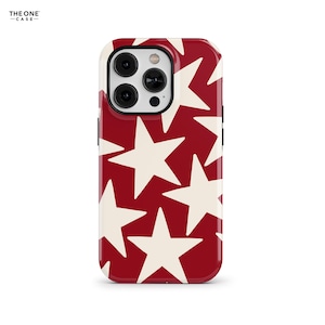 May include: A red phone case with a white star pattern. The case is designed for an iPhone 13 Pro Max.