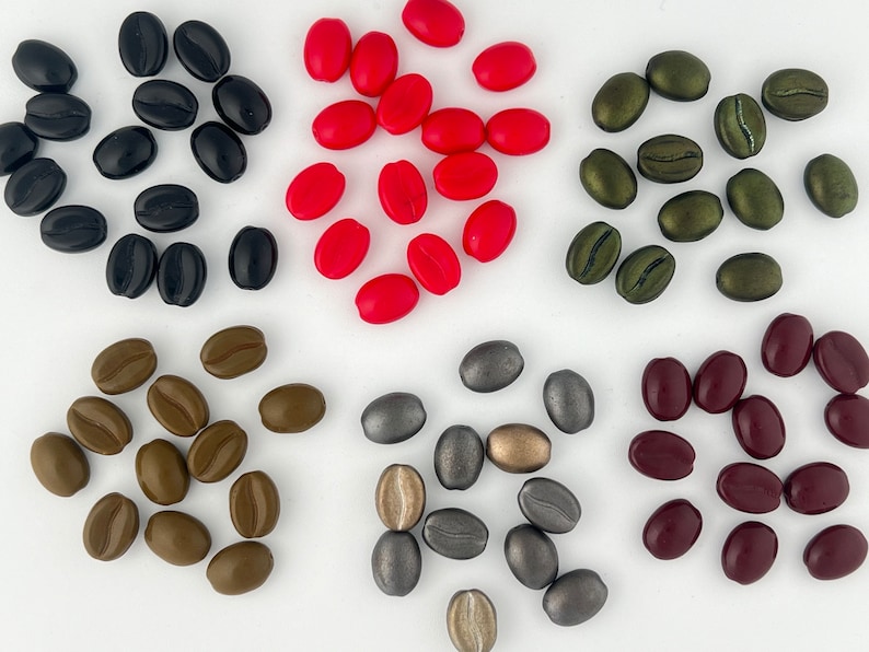May include: Assortment of coffee bean shaped beads in various colors, including red, brown, green, burgundy, and silver.