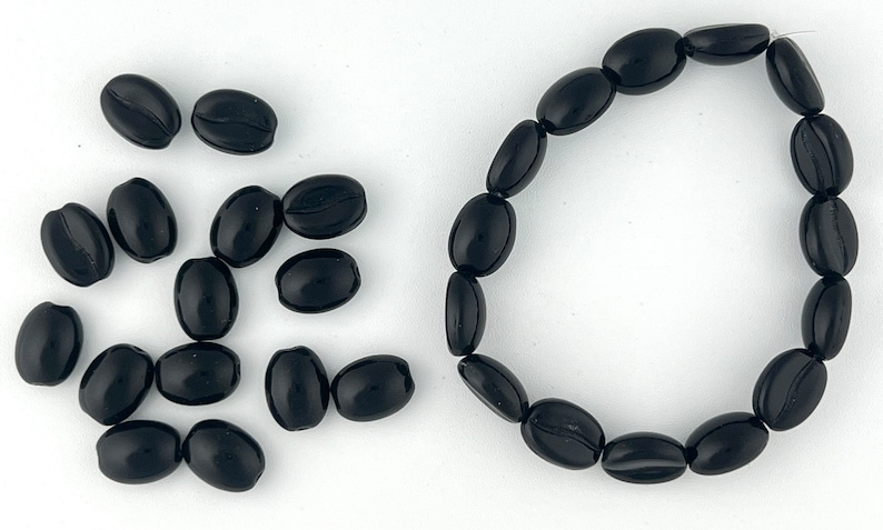 May include: A set of black coffee bean shaped beads, some loose and some strung together in a bracelet.