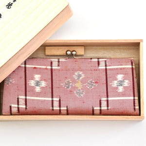 Bonita cartera japonesa larga de tela ikat con estampado geométrico rosa y cierre textil tradicional, Ryukyu Kasuri, Okinawa, Japón.