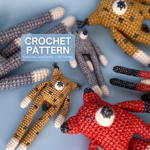 May include: Crochet pattern featuring handmade stuffed animal toys in various colors. The toys include long-legged creatures in shades of gold, gray, and red, with white and black accents. The image includes the text "CROCHET PATTERN".