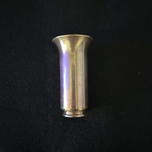 Op de afbeelding: Een glanzende, zilverkleurige metalen trechter met een brede, uitlopende bovenkant en een smalle, cilindrische onderkant.