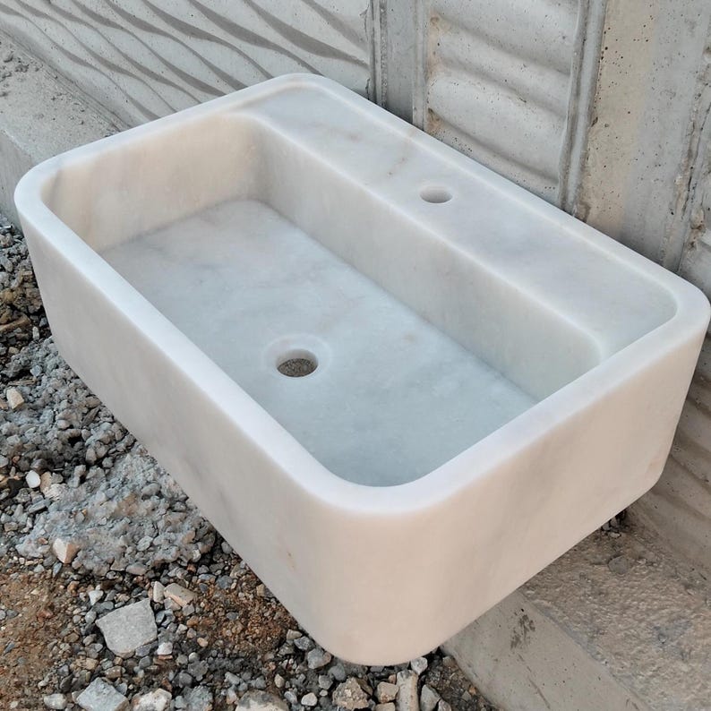 Rectangular Carrara marble sink with soft veining, ideal for a modern bathroom or powder room.