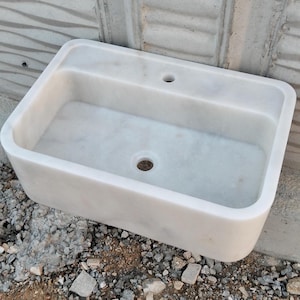 Freestanding Carrara marble sink with natural veining, creating a luxurious focal point.