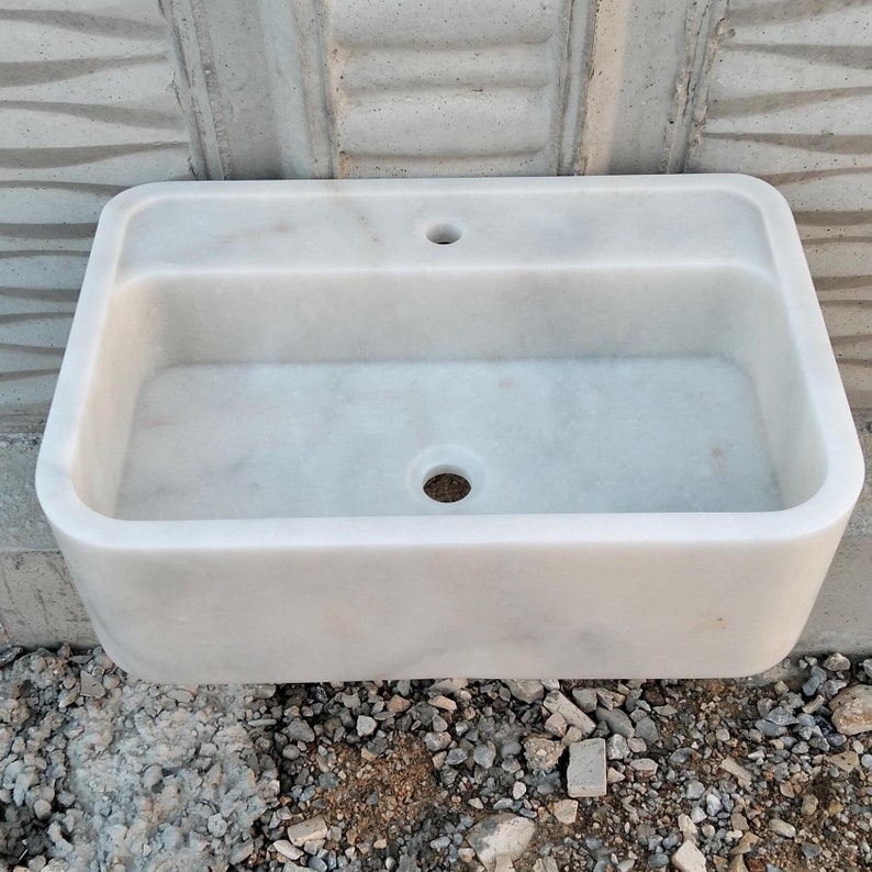 Handcrafted Carrara marble sink with soft gray veining, perfect for modern bathrooms.