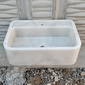 Elegant Carrara marble sink on a countertop, showcasing natural stone beauty.