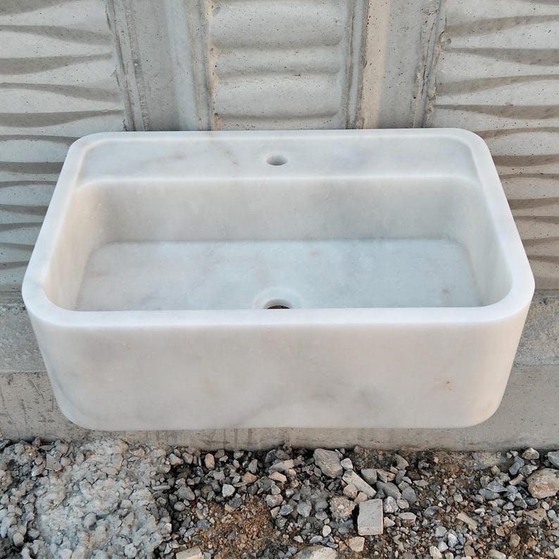 Elegant Carrara marble sink on a countertop, showcasing natural stone beauty.