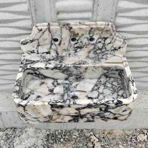Handcrafted Calacatta Viola marble sink with unique natural veining, paired with a stylish backsplash for added sophistication.
