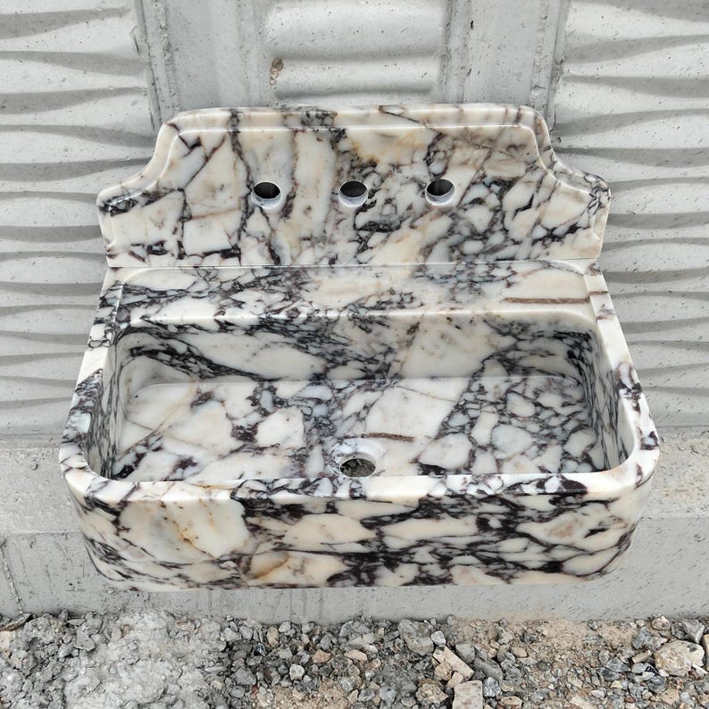 Handcrafted Calacatta Viola marble sink with unique natural veining, paired with a stylish backsplash for added sophistication.