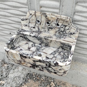 Calacatta Viola marble sink with a polished backsplash, showcasing fine craftsmanship and premium natural stone.