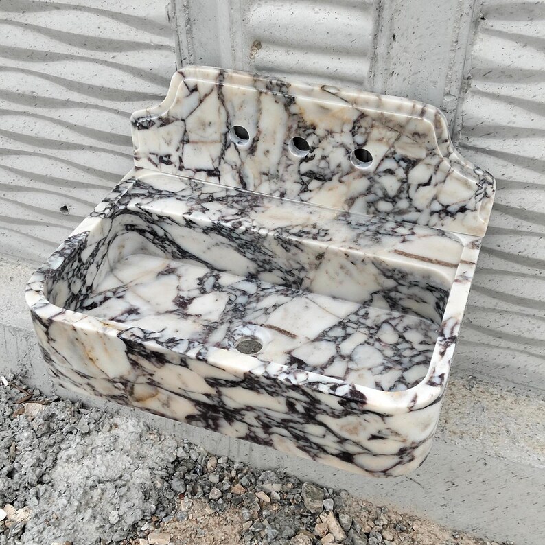 Calacatta Viola marble sink with a polished backsplash, showcasing fine craftsmanship and premium natural stone.