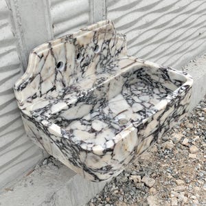 A luxurious rectangular Calacatta Viola marble sink with a backsplash, blending timeless beauty with functionality.