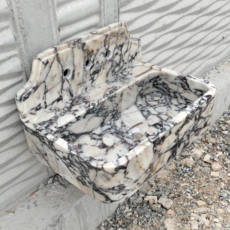 A luxurious rectangular Calacatta Viola marble sink with a backsplash, blending timeless beauty with functionality.