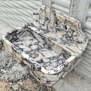 Natural stone sink crafted from Calacatta Viola marble, featuring a chic backsplash and unique veining patterns.