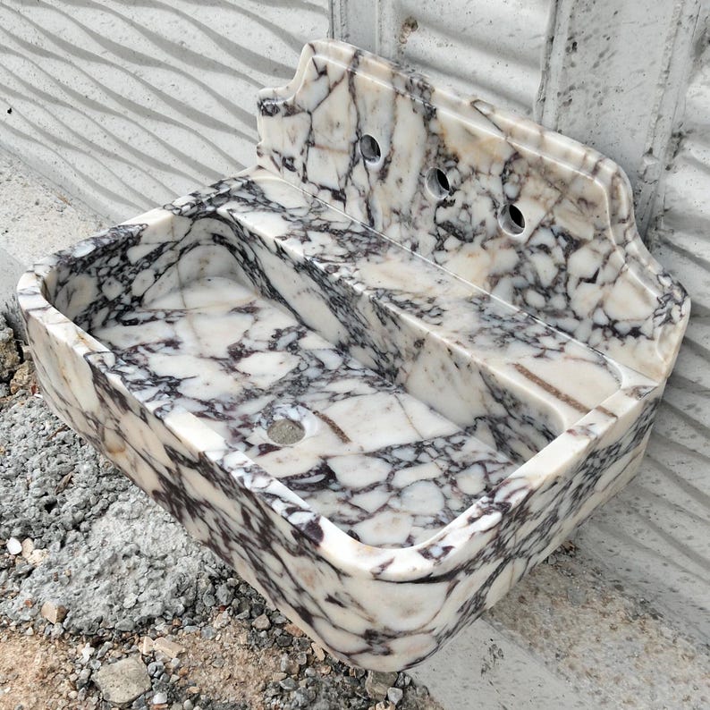 Natural stone sink crafted from Calacatta Viola marble, featuring a chic backsplash and unique veining patterns.