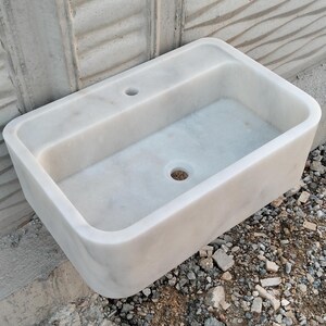 Close-up of the unique veining on a Carrara marble sink, highlighting its natural charm.