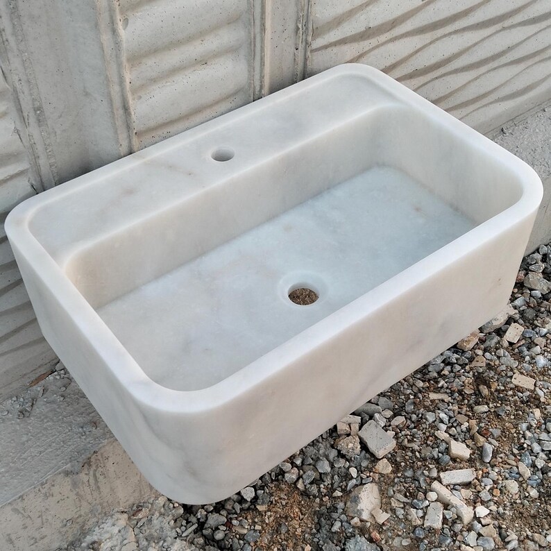 Close-up of the unique veining on a Carrara marble sink, highlighting its natural charm.